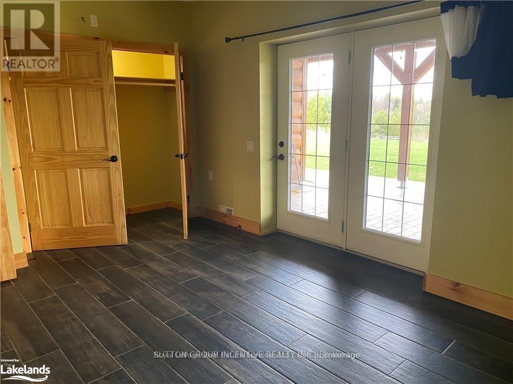 A room with a wooden door and sliding glass doors leading outside.