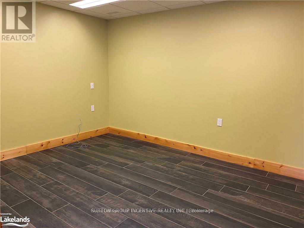 A room with wooden flooring and beige walls.