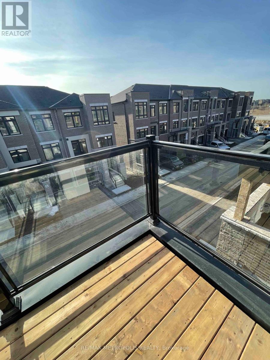 A balcony with a glass railing overlooking a residential area.