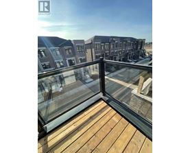 A balcony with a glass railing overlooking a residential area.