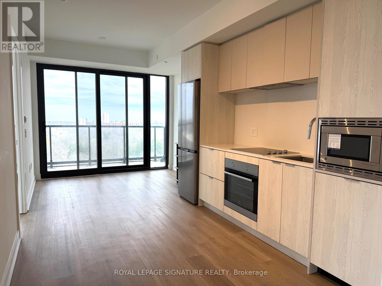 A kitchen with wooden cabinets and a microwave on the counter.