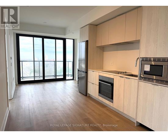 A kitchen with wooden cabinets and a microwave on the counter.