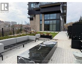 A modern building with a pool in the foreground and a fence surrounding the property.