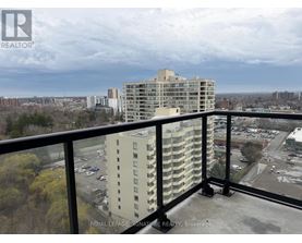A view from a balcony of a multi-story building with a parking lot in the foreground.