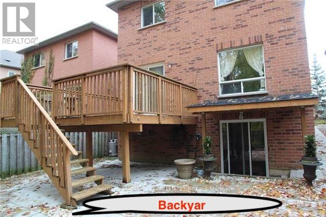 A backyard with a deck and a house.