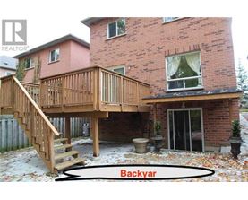 A backyard with a deck and a house.