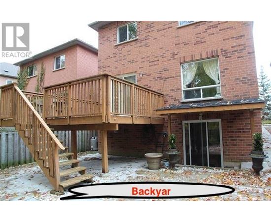A backyard with a deck and a house.