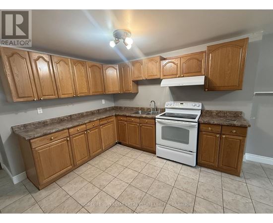 A kitchen with wooden cabinets and a white stove top oven.
