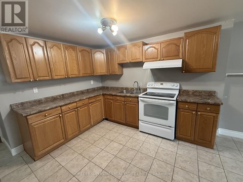 A kitchen with wooden cabinets and a white stove top oven.
