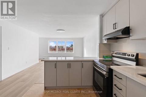 A kitchen with a stove top oven and cabinets.