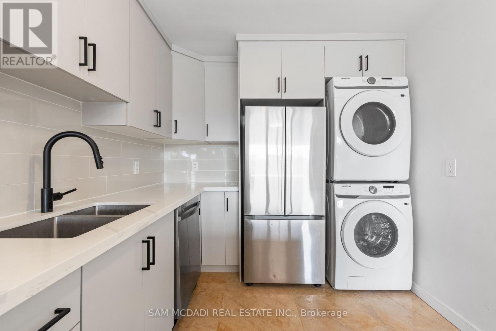 A modern kitchen with a washer and dryer built into the cabinetry.