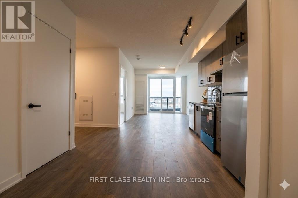 A kitchen area with a refrigerator, sink, and cabinets.
