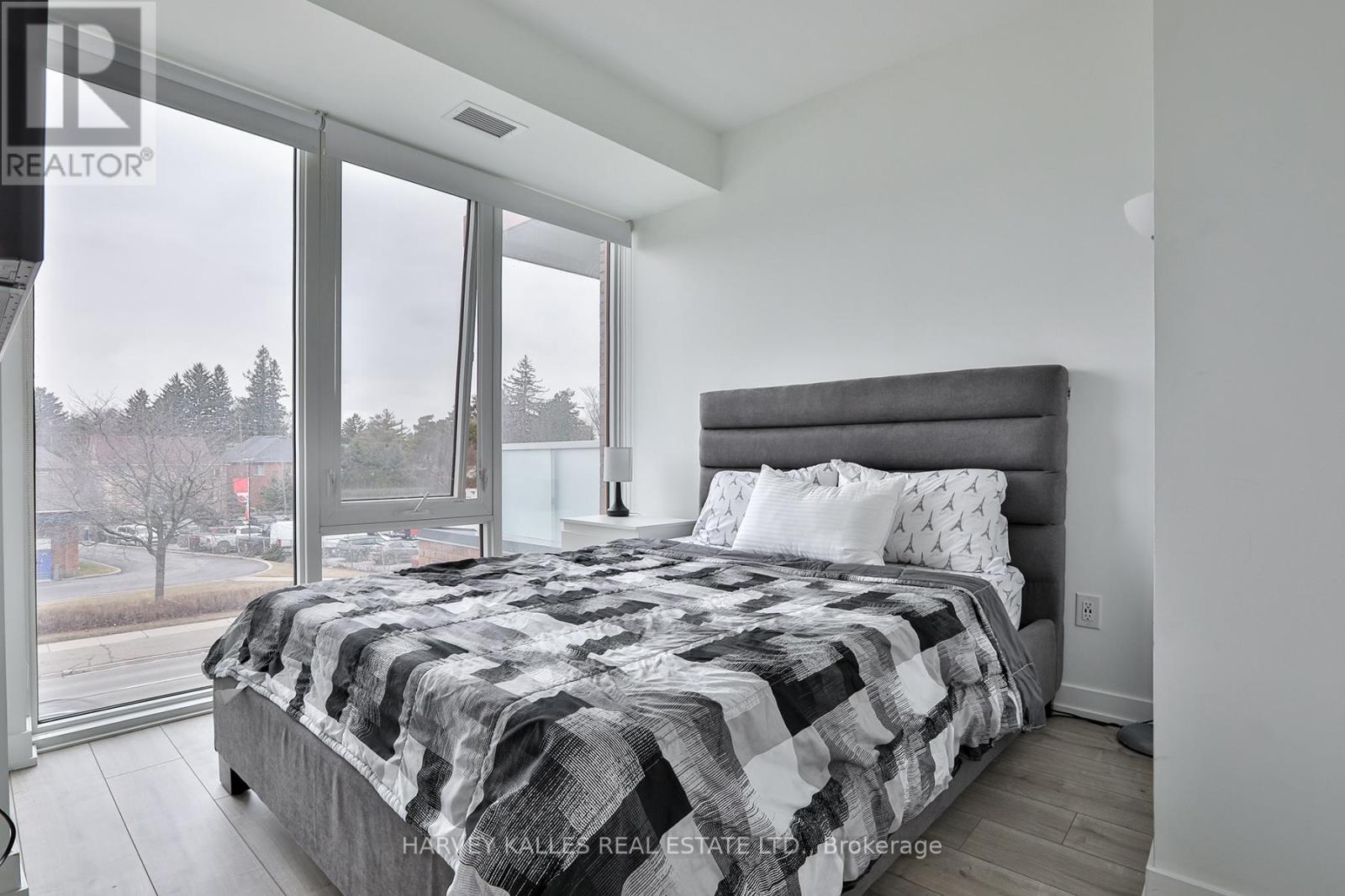 A bedroom with a large bed and a view of a snowy landscape outside the window.