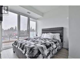 A bedroom with a large bed and a view of a snowy landscape outside the window.