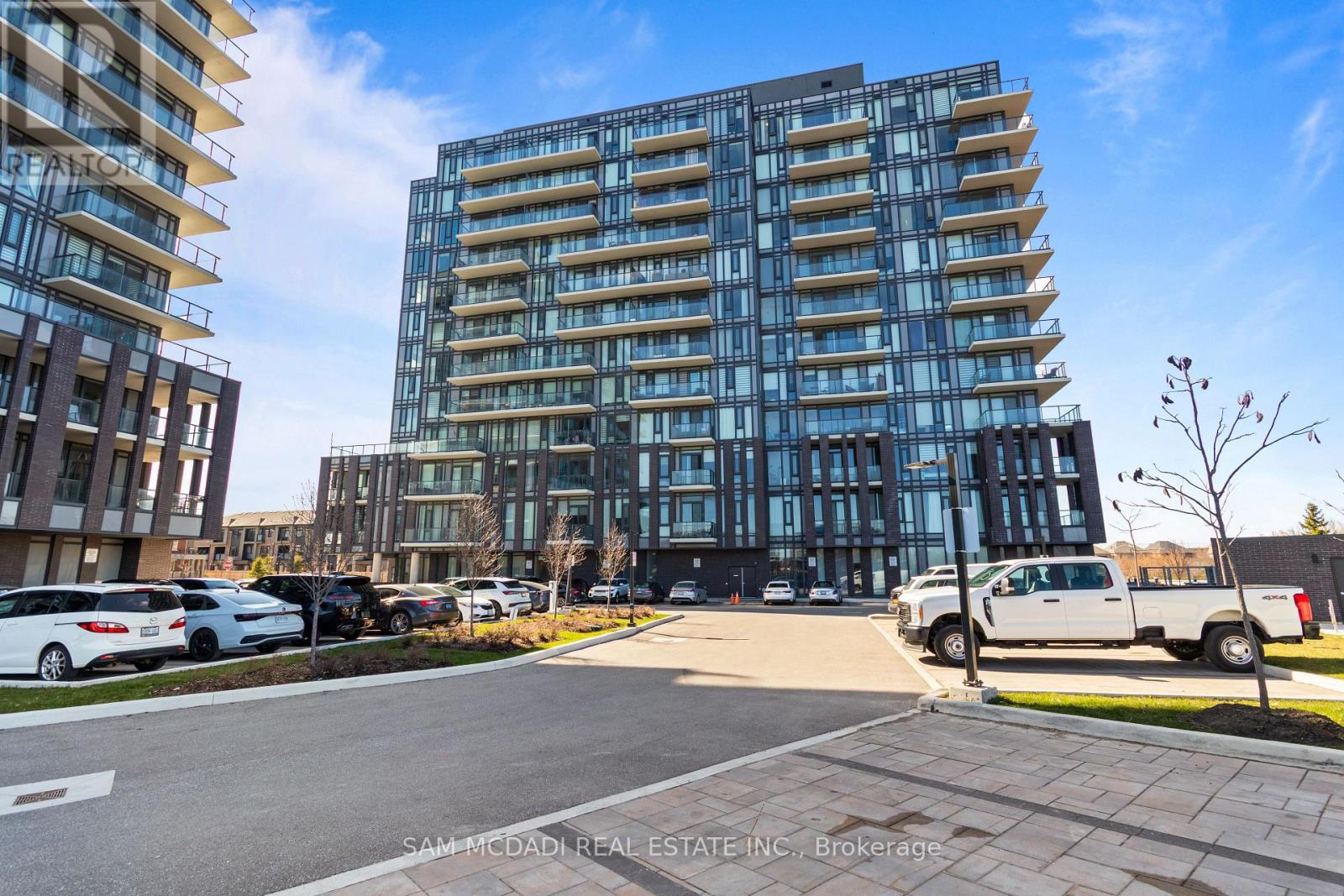 A modern multi-story building with a glass facade is the focal point of the image.