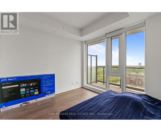 A bedroom with a large bed and a flat screen TV.