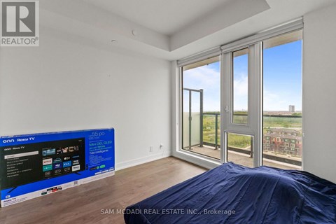 A bedroom with a large bed and a flat screen TV.