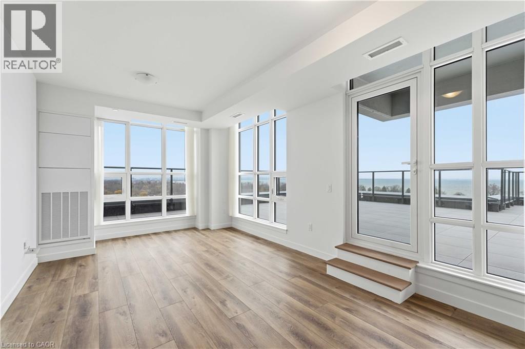 A spacious room with wooden floors and large windows.