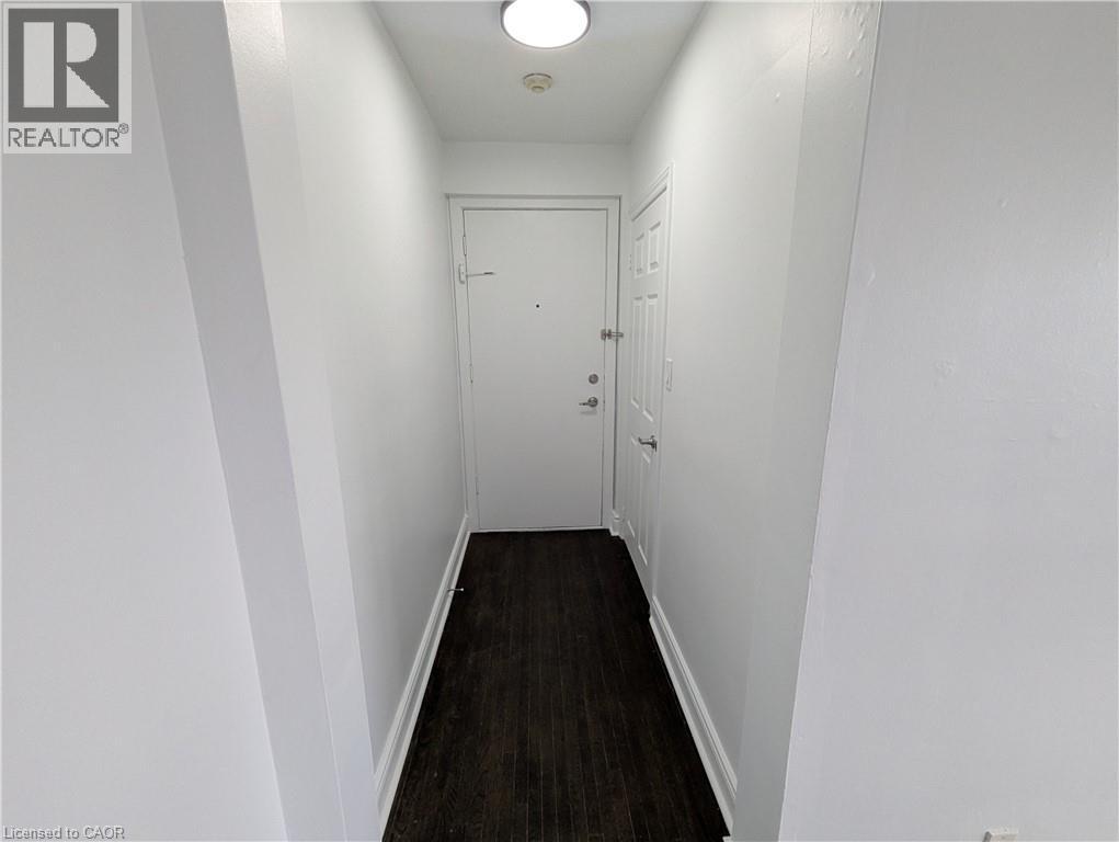 A hallway with a white door and a light on the ceiling.