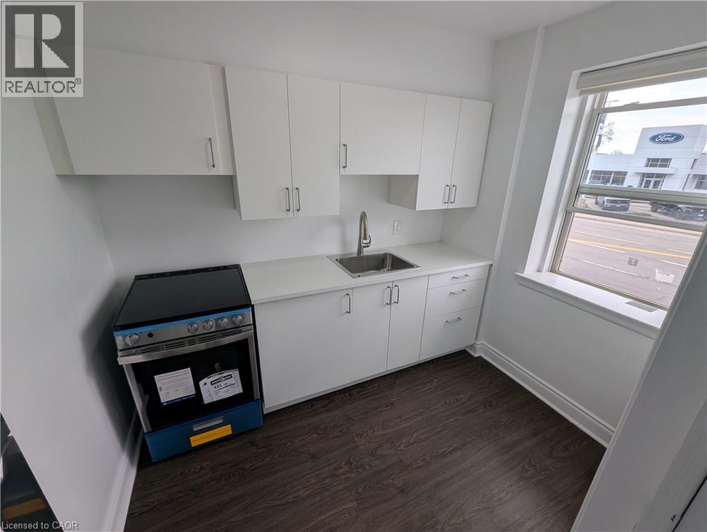 A kitchen with white cabinets and a black oven.