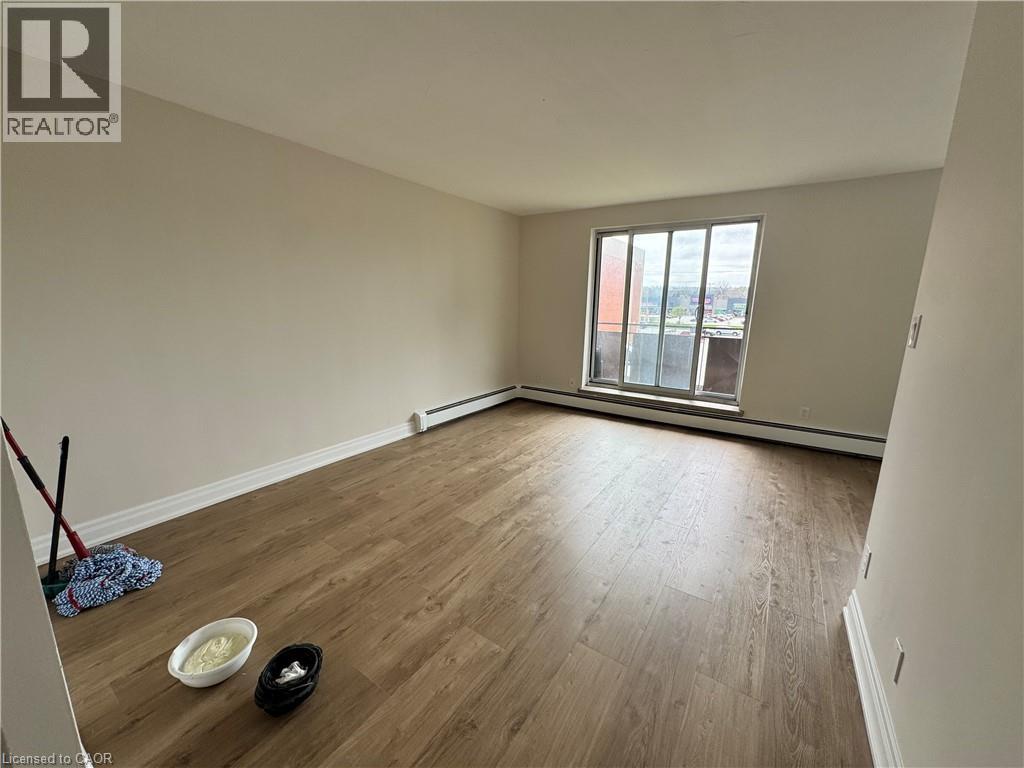 A room with a window and a wooden floor.