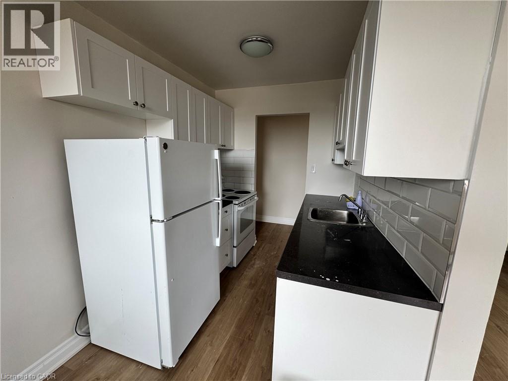 A kitchen with white cabinets and a black countertop.