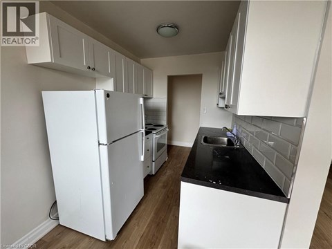 A kitchen with white cabinets and a black countertop.
