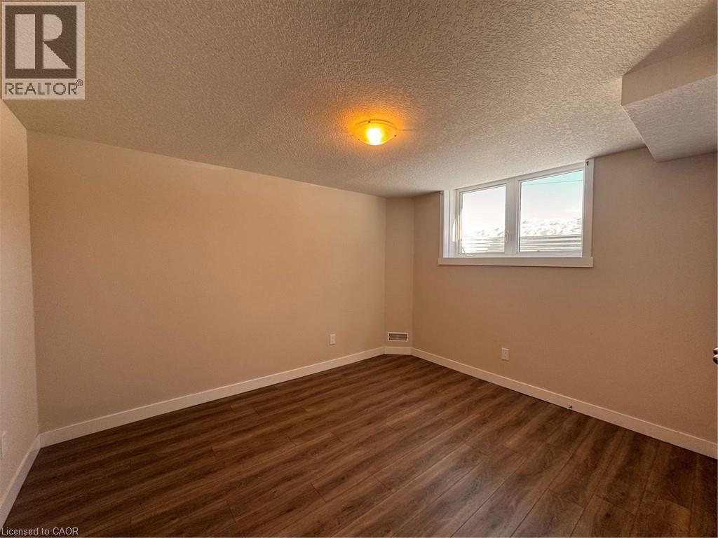 A room with wooden flooring and a window with blinds.
