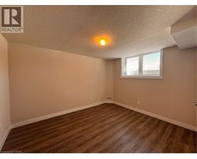 A room with wooden flooring and a window with blinds.