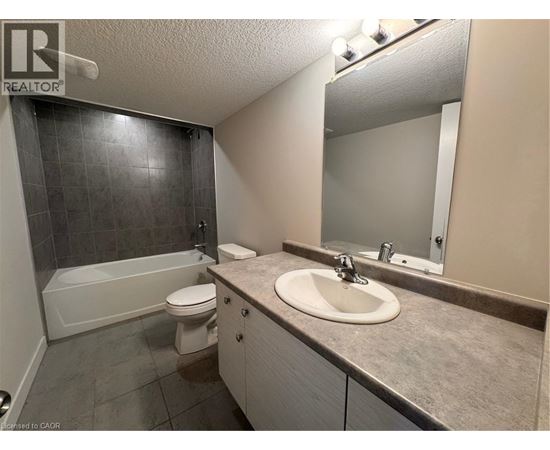 A bathroom with a sink, toilet, and bathtub.