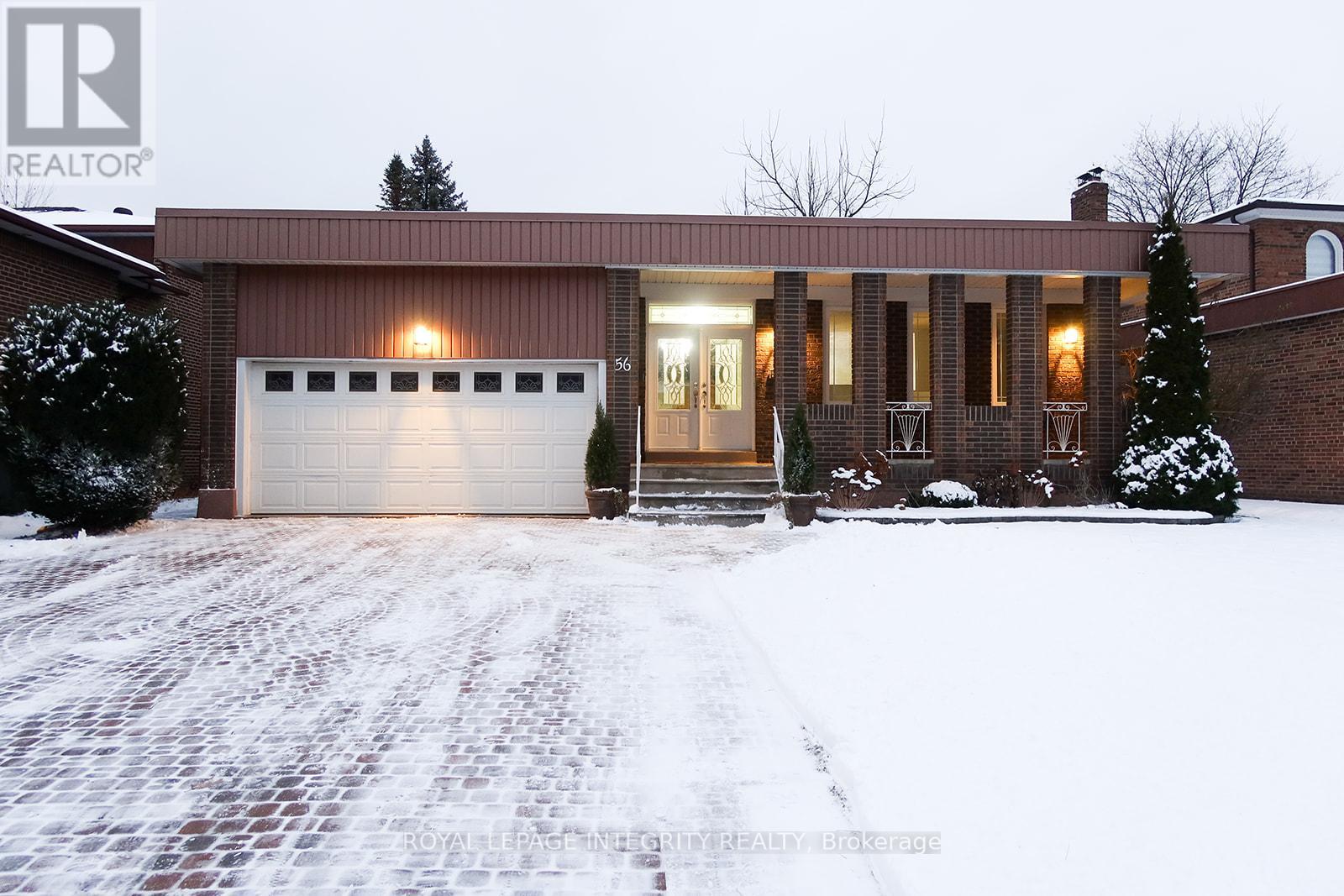 A house with a garage and a driveway covered in snow.