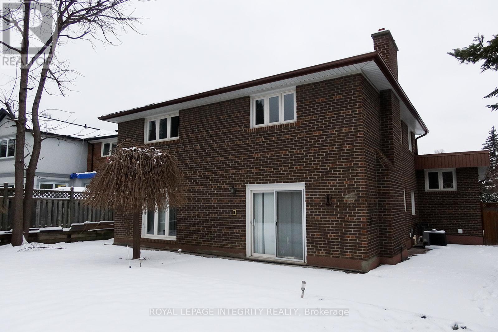 A house with a brown brick exterior and a white roof.
