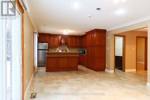 A kitchen with brown cabinets and a tiled floor.