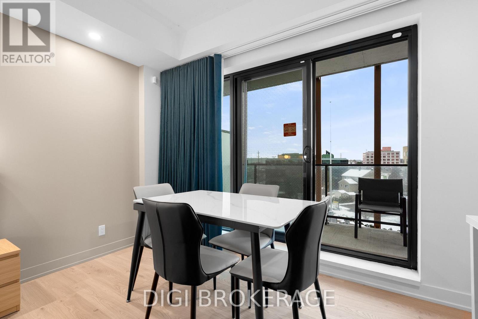 A dining room with a table and chairs and a view of the outside.