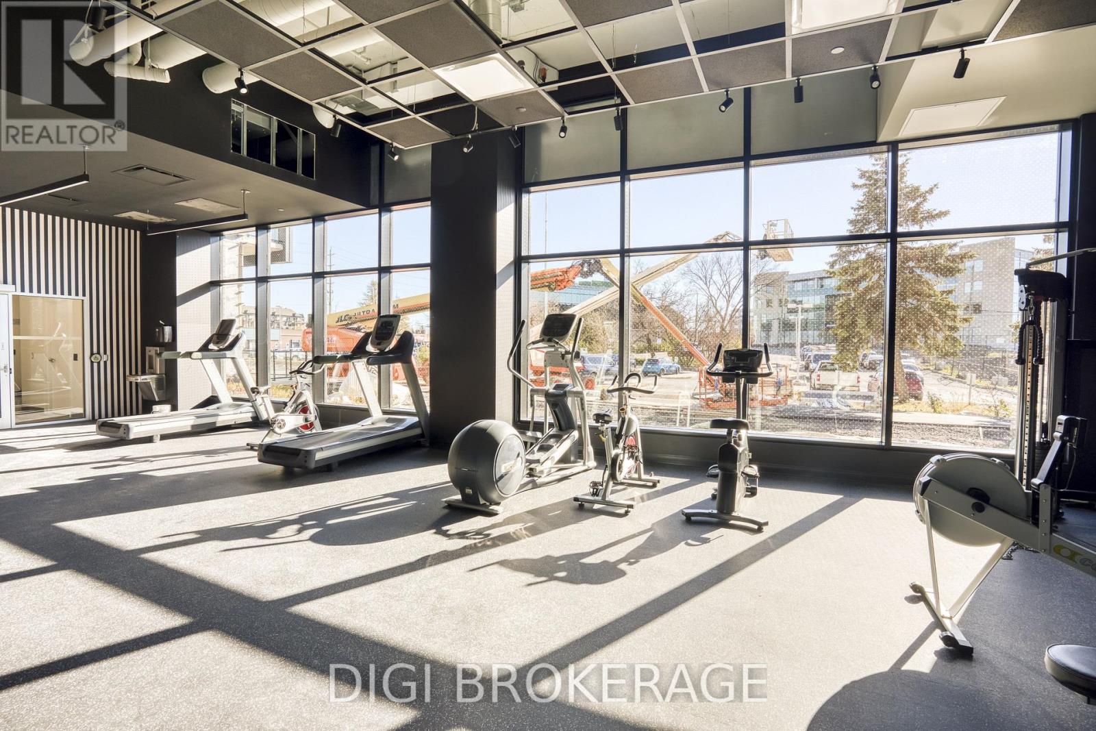 A gym with a row of exercise bikes and a row of dumbbells.