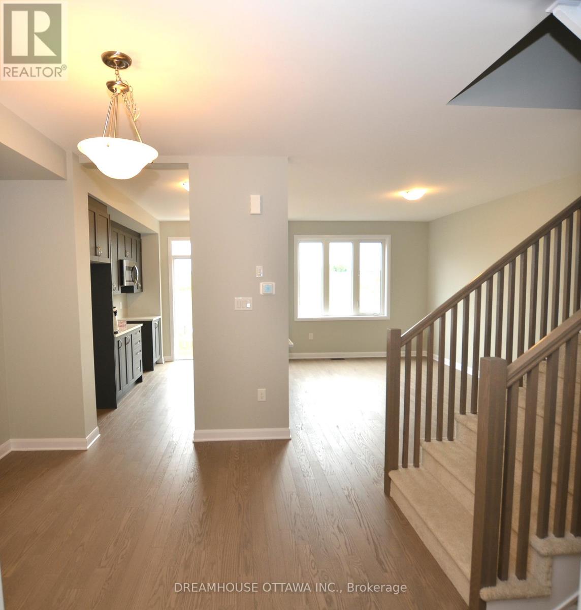 A large open space with wood floors and a staircase.