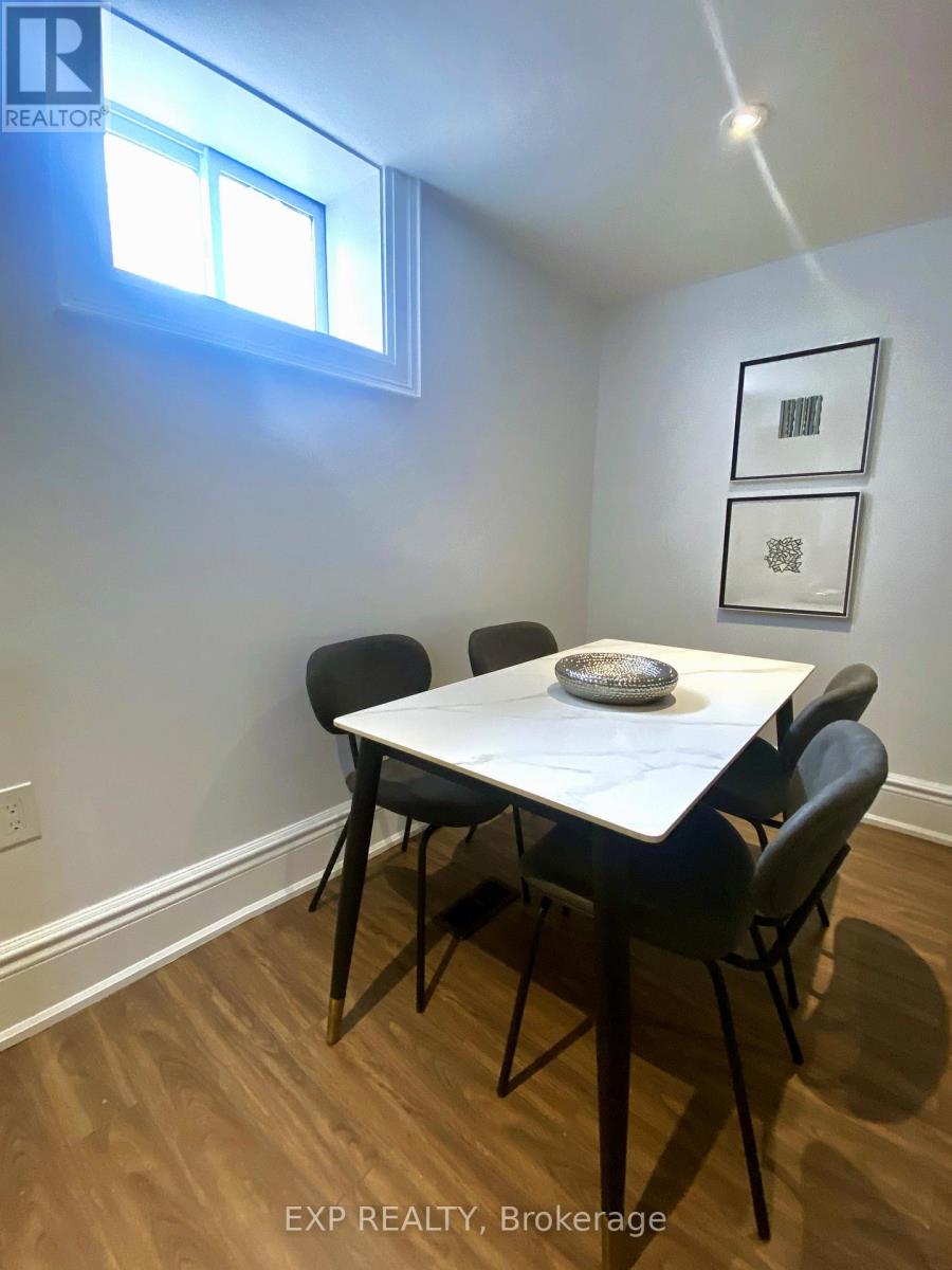 A dining room with a white table and black chairs.