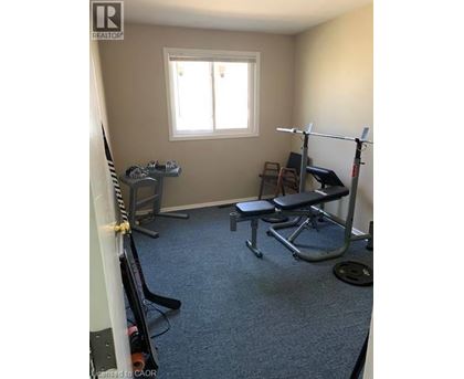 A home gym with a squat rack, bench, and weights.