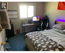 A bedroom with a bed, desk, and chair.