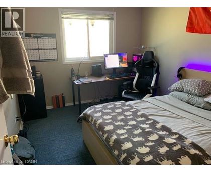 A bedroom with a bed, desk, and chair.