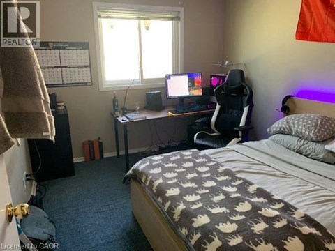 A bedroom with a bed, desk, and chair.