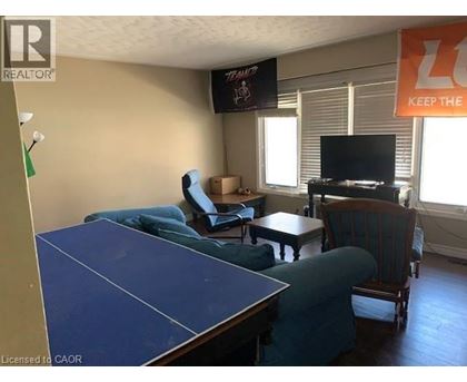 A living room with a blue table and a TV on the wall.