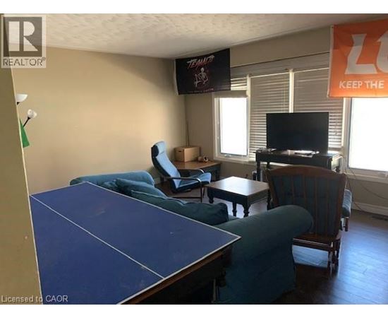 A living room with a blue table and a TV on the wall.