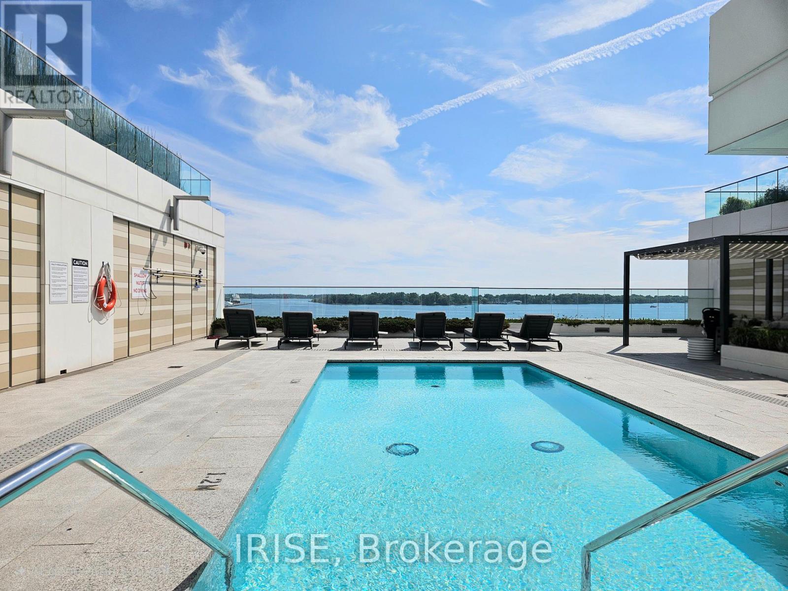 A swimming pool with chairs around it and a sign that says "REALTOR".