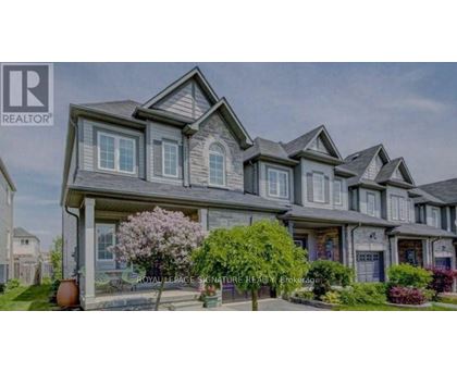 A large, multi-level house with a well-manicured front yard.