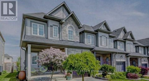 A large, multi-level house with a well-manicured front yard.