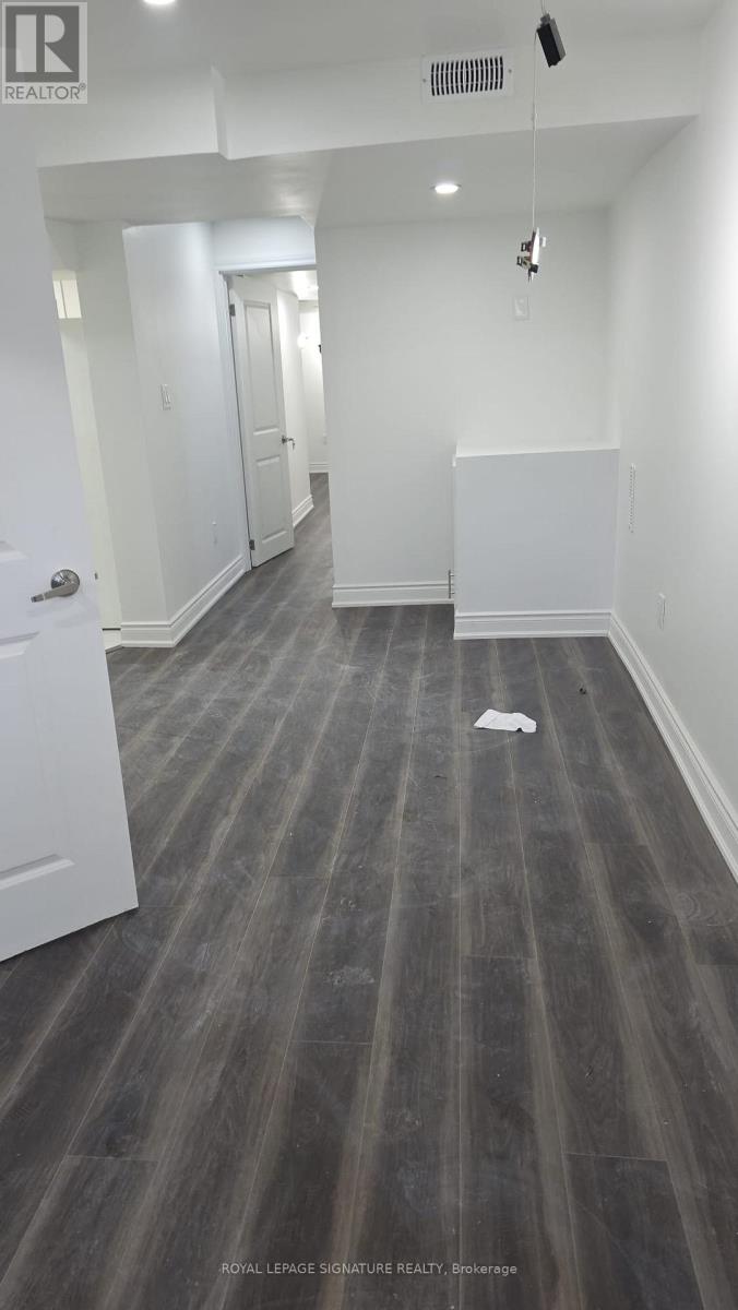 A long hallway with a white door on the left and a white wall on the right.