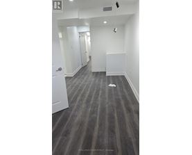 A long hallway with a white door on the left and a white wall on the right.