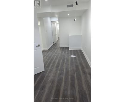 A long hallway with a white door on the left and a white wall on the right.