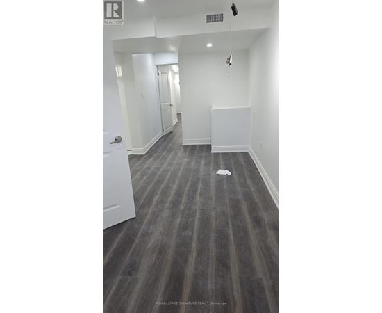 A long hallway with a white door on the left and a white wall on the right.